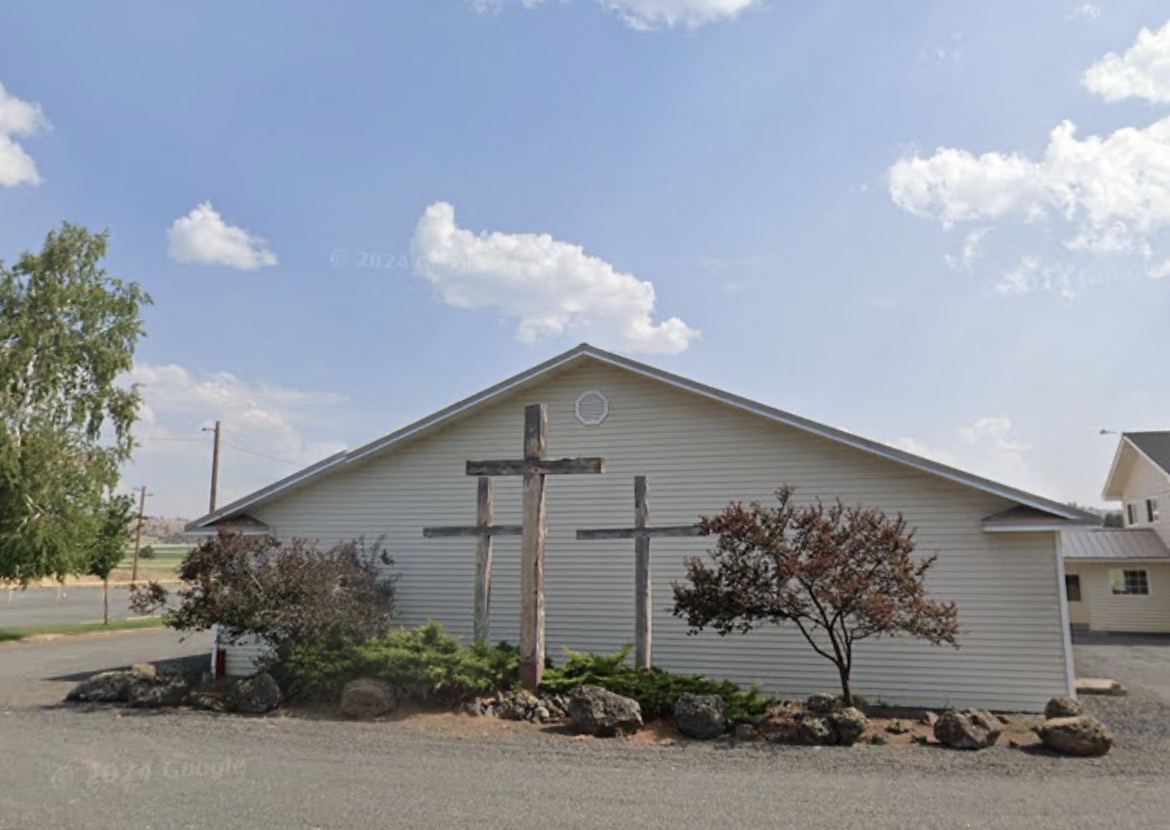 Exterior of Bonanza Community Church with three wooden crosses