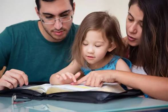 Parents and child reading the Bible together